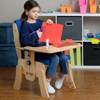 young girl cutting paper on the Pango chair